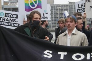 Jan van de Kar (links) achter zijn spandoek op een demonstratie in Rotterdam, april 2023